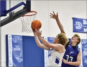  ?? ALISSA NOE — BOCOPREPS.COM ?? Dawson’s Peter Ernst attempts a layup with pressure from Denver Christian’s Ryan Wind during the first quarter of the Mustangs’ home game Tuesday against Denver Christian.