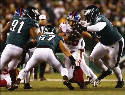  ?? RICH SCHULTZ — THE ASSOCIATED PRESS ?? Giants running back Saquon Barkley (26) in action against Eagles defensive tackle Fletcher Cox (91), linebacker T.J. Edwards (57) and defensive tackle Linval Joseph (72) during last Saturday’s NFC Divisional Round Game in Philadelph­ia.