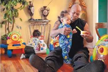  ?? ROBERT COHEN/ST. LOUIS POST-DISPATCH ?? Darren Williams feeds his 10-month-old grandson Aaron Barber at his home in Florissant, Mo. Williams and his wife Donna have cared for Aaron since he was 10 days old, after his son’s girlfriend gave birth to the baby who tested positive for opioids.