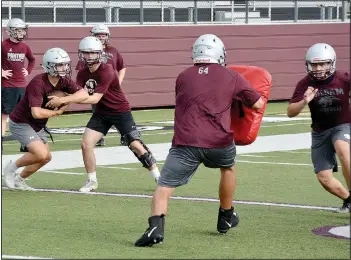  ?? (NWA Democrat-Gazette/Graham Thomas) ?? Running back Cam Collins takes the handoff from Andrew Pilcher during a running drill at football practice on Monday.