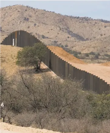  ?? Guillermo Arias / Associated Press 2008 ?? Above: Migrants near Nogales, Mexico, walk toward the 650-mile-long wall separating the U.S. from its southern neighbor in 2008.