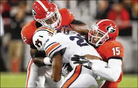  ?? BOB ANDRES / BANDRES@AJC.COM ?? Georgia linebacker­s Monty Rice and D’Andre Walker (15) stop Auburn running back JaTarvious Whitlow during the Bulldogs’ Nov. 10 victory.