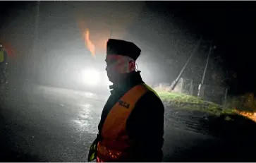  ?? GETTY IMAGES ?? A police officer walks past a check point as permitted cars are allowed to cross into the crime scene yesterday in Przewodow, Poland. Poland convened a meeting of its national security council amid reports that stray missiles hit its territory, killing two people. Russia’s defence ministry denied that its missiles hit the Nato member state.