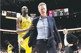  ?? Steve Dykes / Associated Press ?? Warriors forward Kevin Durant escorts Steve Kerr off the floor after the head coach was ejected toward the end of a 129-107 loss at Portland on Wednesday.