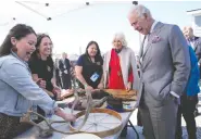  ?? PAUL CHIASSON / THE CANADIAN PRESS ?? Prince Charles and Camilla, Duchess of Cornwall, look at a display of traditiona­l hunting tools and clothing after
arriving in Yellowknif­e during the royal tour Thursday.