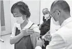  ?? YOHEI NISHIMURA/KYODO NEWS VIA AP ?? A woman gets her first dose of Pfizer’s COVID-19 vaccine in Kitaaiki village, central Japan, Monday, as the nation began vaccinatin­g older residents.