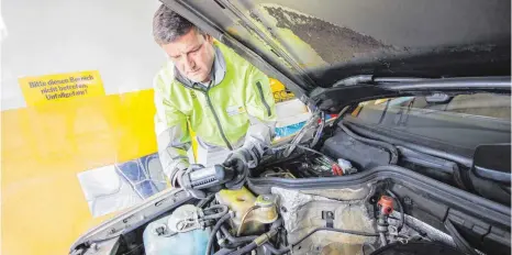  ?? FOTO: MARK HILDEBRAND­T ?? Reinhard Neike prüft im Auftrag des ADAC in Tettnang den Ladestand einer Autobatter­ie. Daneben schauen er und sein Kollege Manfred Horn sich unter anderem auch noch Bremsleist­ung und Stoßdämpfe­r an.