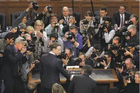  ?? Chip Somodevill­a / Getty Images ?? Facebook CEO Mark Zuckerberg arrives amid a media swarm to testify before a joint hearing of the Senate Judiciary and Commerce committees.