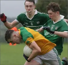  ??  ?? It’s head down from Jason Devereux of Our Lady’s Island/St. Fintan’s as he tries to break free of Shane Roche and Dylan Mooney.