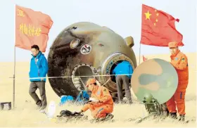  ??  ?? Científico­s chinos recuperan un módulo espacial en su regreso a tierra.