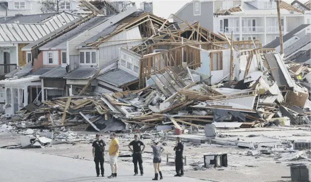  ?? PICTURE: GERALD HERBERT/AP ?? 0 Rescue personnel perform a search in the aftermath of Hurricane Michael – the most powerful to hit the continenta­l US for 50 years