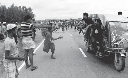  ??  ?? ROHINYÁS. Corren a un vehículo con ayuda humanitari­a cerca de Teknaf, en Bangladés.