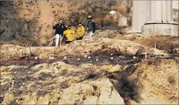  ?? Al Seib Los Angeles Times ?? “OUR MONDAY morning quarterbac­k says, ‘We should’ve shut down that line.’ But when we shut it down you’re mad,” state Sen. Henry Stern said of utilities’ dilemma. Above, fire inspectors look for clues in Sylmar.