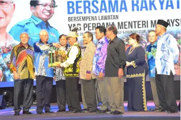  ??  ?? Najib (second left) receives a memento from Kenyah paramount chief Temenggong Joseph Ngau Lian as others look on.