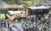  ?? LEE SANG-HAK — YONHAP VIA AP ?? A U.S. military vehicle moves as South Korean police officers try to block residents and protesters opposing deployment Thursday of an advanced U.S. missile defense system called Terminal High-Altitude Area Defense, or THAAD, in Seongju, South Korea.