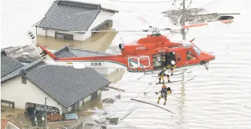  ??  ?? An aerial view shows a local resident being rescued from a submerged house by rescue workers using helicopter at a flooded area in Kurashiki, southern Japan. — Reuters photo