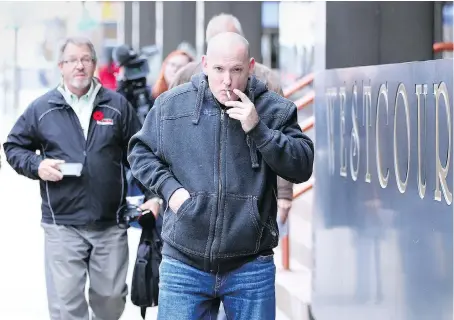  ?? POSTMEDIA ?? Compassion House owner Leo Lucier, centre, makes his way to Windsor Police headquarte­rs on Wednesday. Five people, including Lucier, were to be charged under the new federal Cannabis Act after a Tuesday night raid by the city’s drugs and guns unit.