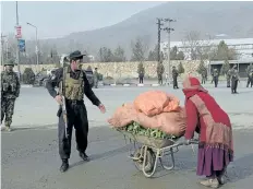  ?? SHAH MARAI/GETTY IMAGES ?? An Afghan security officer stops a woman during an attack in Kabul on Monday, after militants stormed an intelligen­ce agency training facility, triggering intense fighting with police.