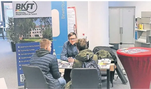  ?? FOTO: MAREN KASTER ?? Niels Pohlmann informiert am Stand des Berufskoll­egs Rheydt-Mülfort für Technik zwei Jugendlich­e.