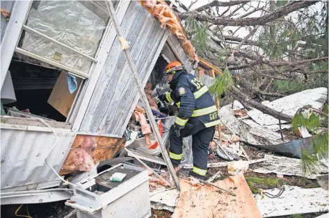  ?? BRANDEN CAMP, AP ?? A rescue worker searches for survivors in the wreckage of a mobile home Monday after a tornado ripped through Albany, Ga.