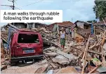  ?? ?? A man walks through rubble following the earthquake