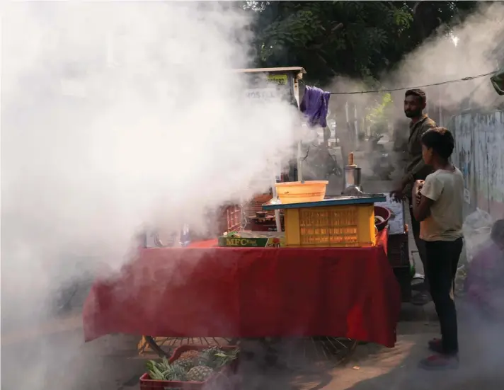  ?? ?? Smoke envelops a food vendor's cart as fumigation is carried out to prevent the spread of mosquito-borne diseases in Prayagraj, in the northern state of Uttar Pradesh, India, yesterday. Photo: AP/Rajesh Kumar Singh.