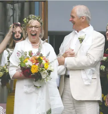  ?? CHAD HIPOLITO / THE CANADIAN PRESS ?? Federal Green Party Leader Elizabeth May and her husband John Kidder greet the crowd as her daughter Cate holds an umbrella following their marriage during Earth Day at the Christ Church Cathedral in Victoria on Monday.