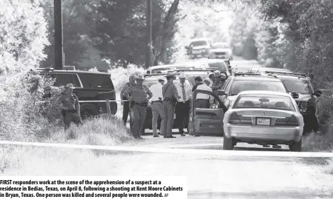  ?? AP ?? First responders work at the scene of the apprehensi­on of a suspect at a residence in Bedias, texas, on April 8, following a shooting at Kent Moore Cabinets in Bryan, texas. One person was killed and several people were wounded.