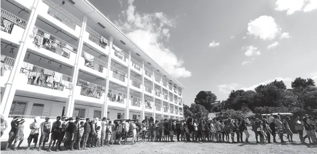  ??  ?? EVACUEES fall in line for the distributi­on of food packs at the evacuation center in Poblacion Central School in Alfonso, Cavite. Some 1,059 evacuees are staying in the evacuation center since Taal Volcano erupted. PNA photo