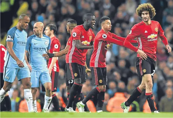  ??  ?? Marouane Fellaini is shepherded off the pitch by team-mates following his dismissal against Manchester City.
