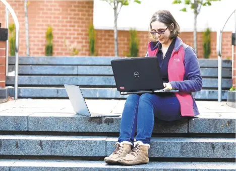  ?? AMY SHORTELL/THE MORNING CALL ?? Erica Panella, a certified recovery specialist for Lehigh County, works remotely on the steps of the Lehigh County Government Center to keep in contact with her clients who may feel more isolated during the coronaviru­s pandemic.