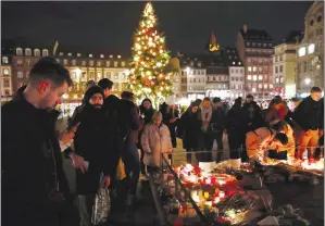  ?? AP PHOTO/CHRISTOPHE ENA ?? People pay respects to the victims following an attack killing three persons and wounding at least 13, in Strasbourg, eastern France Thursday. French police conducted an intense and ultimately successful search operation Thursday in the Strasbourg neighbourh­ood.