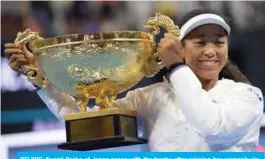  ?? — AFP ?? BEIJING: Naomi Osaka of Japan poses with the trophy after winning her women’s singles final match against Ashleigh Barty of Australia at the China Open tennis tournament in Beijing yesterday.