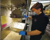  ?? PHOTOS BY JOEL ROSENBAUM — THE REPORTER ?? Kaleb Scott, 19 of Vacaville empties out freshly made popcorn as he gets ready for the reopening of the Brenden Theater Wednesday in Vacaville. Scott has worked at the theater for two years and said it felt great to be back.