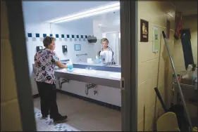  ?? GRETCHEN ERTL / THE NEW YORK TIMES ?? Avelina Mendes, a custodian, works Sept. 15 in Easton, Mass. A parallel universe of millions of employees did not have the luxury of thinking about returning to the office — they never left.