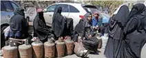  ?? - Reuters ?? IN SHORT SUPPLY: Women wait to fill up cooking gas cylinders outside a gas station amid supply shortage in Sanaa, Yemen on November 7, 2017.