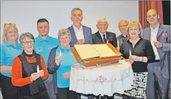  ??  ?? Members of the Oban Hospice board and friends with the 2018 Light Up A Life book of remembranc­e.