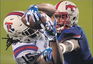  ?? Ronald Martinez Getty Images ?? KAM McKNIGHT of Louisiana Tech hauls in a touchdown pass despite tight defensive pressure Wednesday.