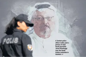  ?? AP ?? A Turkish police officer walks past a picture of slain Saudi journalist Jamal Khashoggi near the Saudi Arabia consulate in Istanbul.