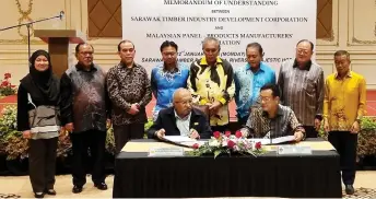 ?? ?? Zainal Abidin (right) and Sheikh Othman sign the MoU documents, witnessed by Len Talif (back, fourth right) and other officials.