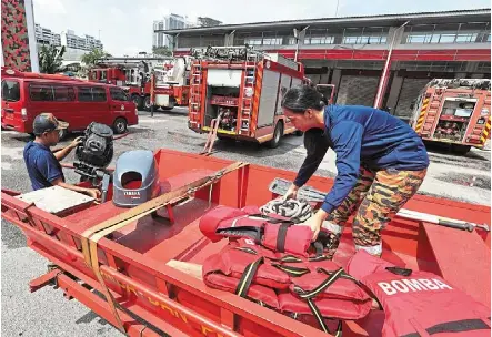  ?? — azman Ghani/the Star ?? All hands on deck: Jalan Hang tuah Fire and rescue Station personnel checking on a rescue boat in Kuala Lumpur.