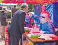  ?? ?? Above: Residents take polymerase chain reaction test in a community in the Pudong New Area. — IC