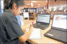  ?? SUZANNE TENNANT/POST-TRIBUNE PHOTOS ?? Munster junior Jenai Panora does her history homework on her laptop in the library at lunchtime.