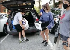  ?? HYMAN/THE NEWS & OBSERVER VIA AP ?? In this Aug. 18 file photo, Miranda Darwin, from Raleigh and a freshman at UNC-Chapel Hill, center, gets help from her brother, Sam, and her mother, Stacy, while moving out of her room at Hinton James residence hall in Chapel Hill, N.C. ETHAN