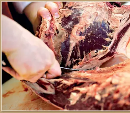  ??  ?? A piece of beef is cut at a supermarke­t in the US.