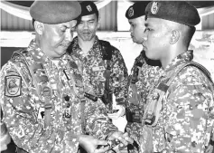  ??  ?? Fadzil (left) pins a badge on Faizul’s uniform.