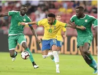  ?? ROSLAN RAHMAN/AFP ?? KAWAL KETAT: Neymar Jr dipepet pemain Senegal Salif Sane (kanan) dan Cheikhou Kouyate dalam laga di National Stadium, Singapura, tadi malam.