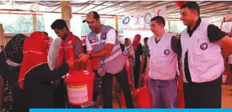  ??  ?? Kuwait Red Crescent Society (KRCS) workers distribute aid to Rohingya refugees in Bangladesh.