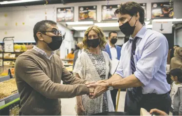  ?? CARLOS OSORIO / REUTERS ?? Prime Minister Justin Trudeau wears a loose-fitting mask while greeting resettled Afghan families in Hamilton, Ont.