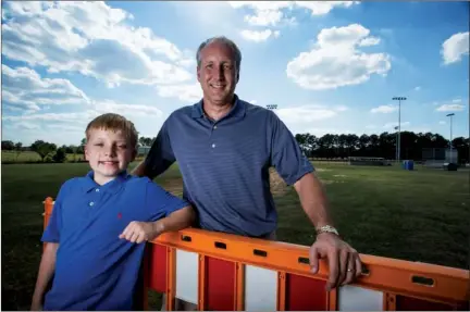  ??  ?? PHOTOS BY NICK HILLEMANN/RIVER VALLEY & OZARK EDITION Above: David Grimes and his son John David stand at the location of a future Miracle League baseball field in Conway. Below: The father and son play catch at the site, which is also proposed to...